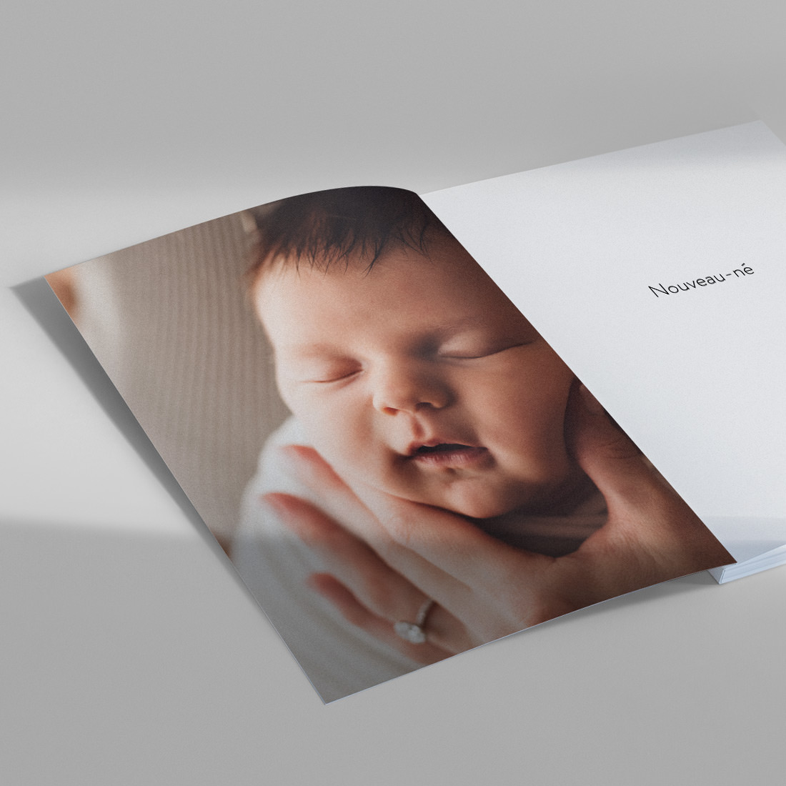 Magazine pour bébés ouvert avec photo d'un bébé endormi sur la page couverture