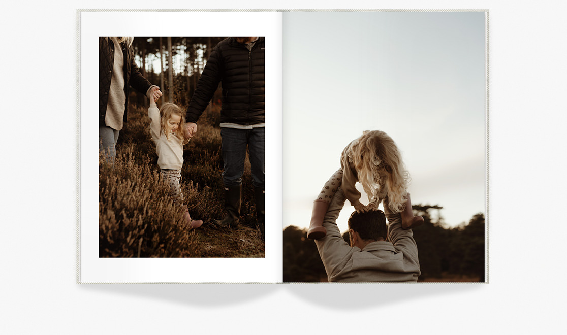 Open Portrait Premium Photo Book of father and daughter walking through field at dusk.