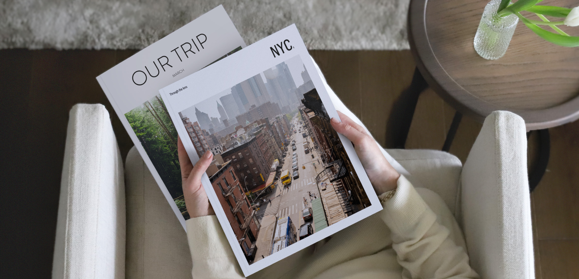 Two MILK Travel Magazines held while seated in beige living room.