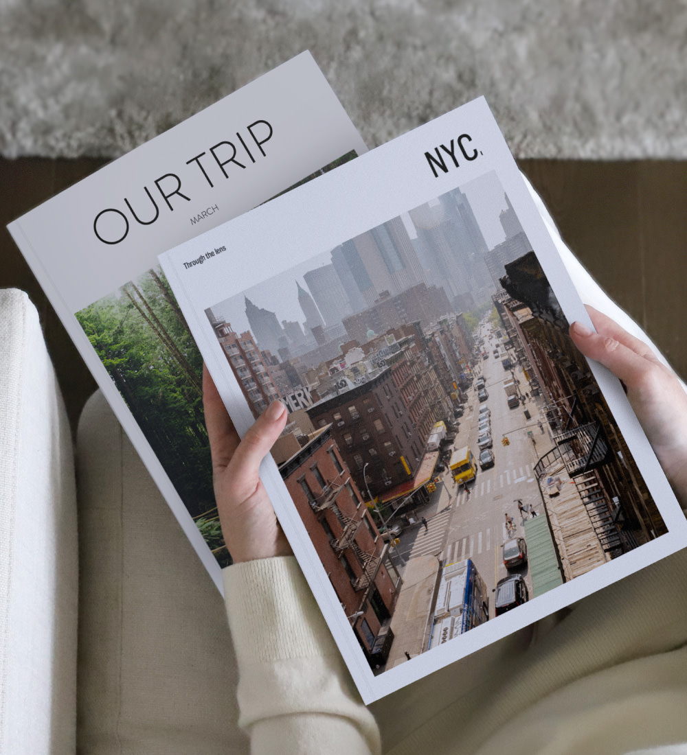 Two MILK Travel Magazines held while seated in beige living room.