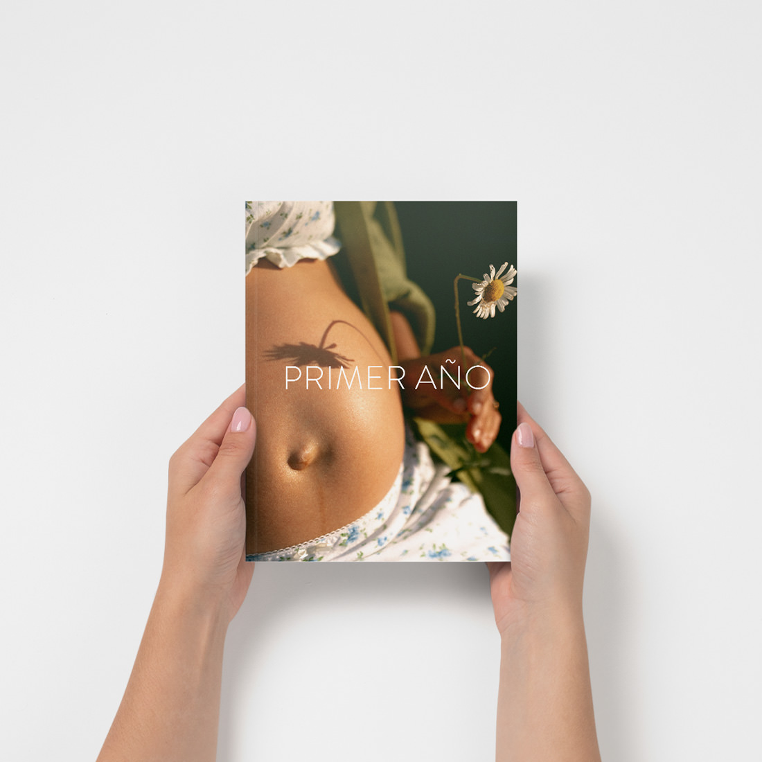 Revista mini de bebés sostenida en las manos