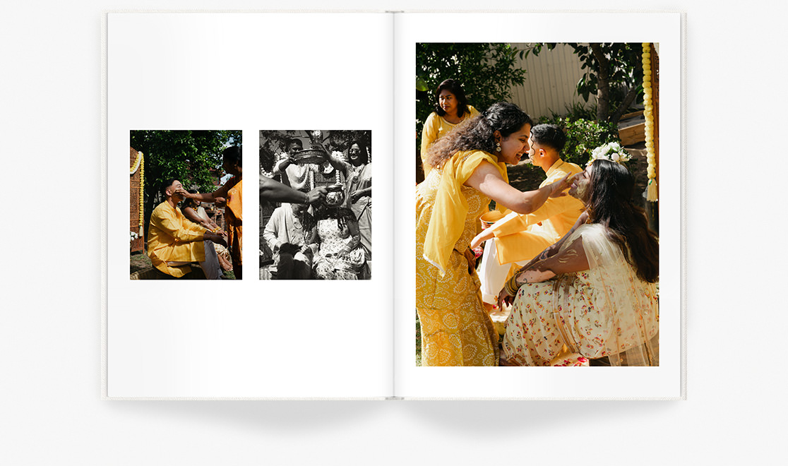 Indian family in yellow attire smile spreading paste on face of bride at wedding ceremony.