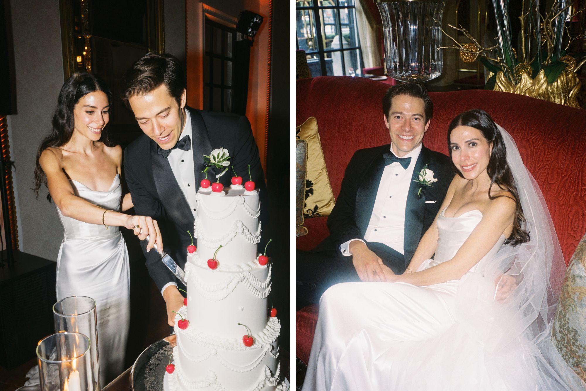 Newlywed couple happily cut three-tier white piped wedding cake with red cherries on top.