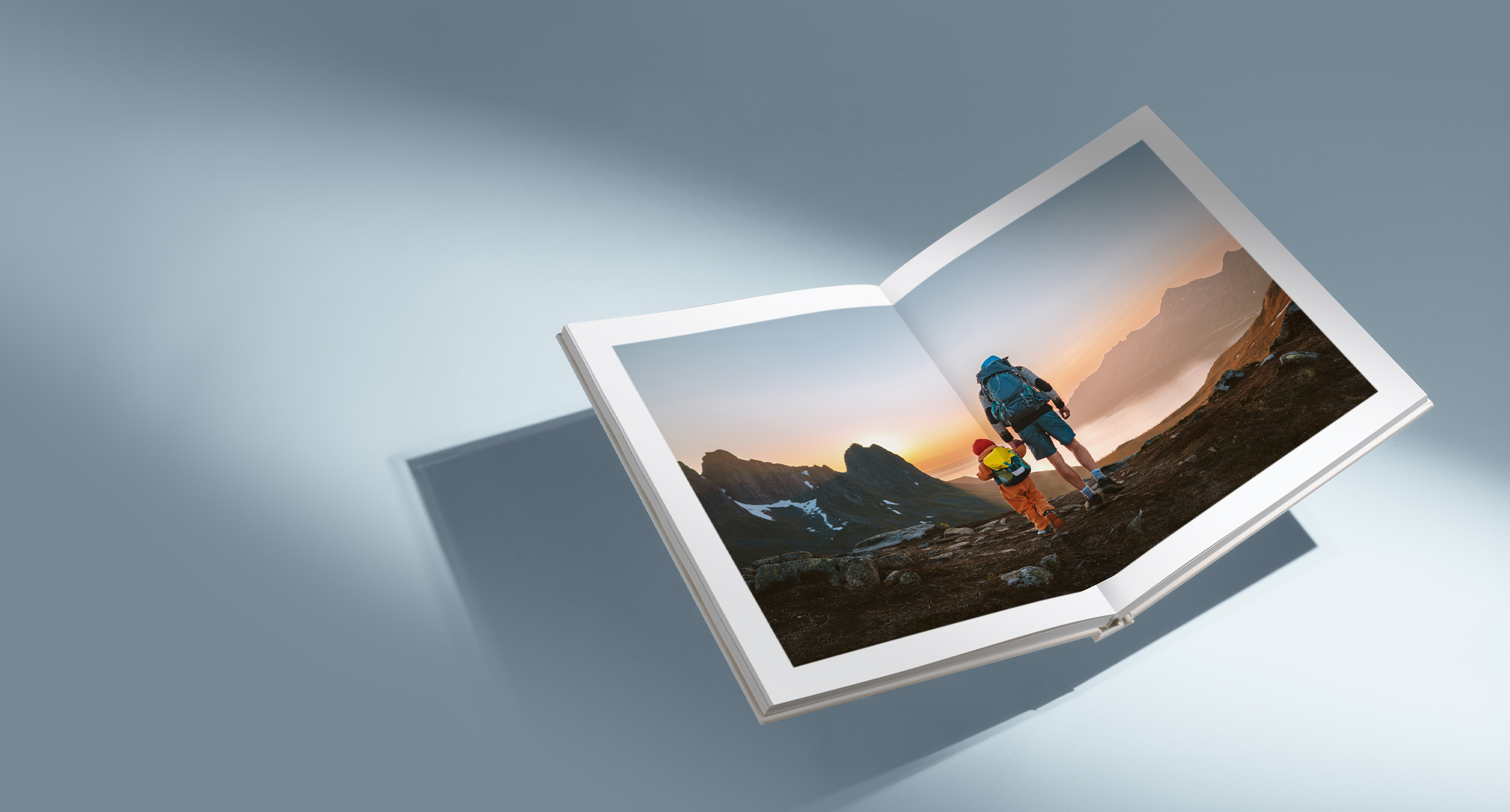 Open Premium Photo Album with photo of a father and son in climbing gear holding hands walking through rocky mountains inside double page spread.