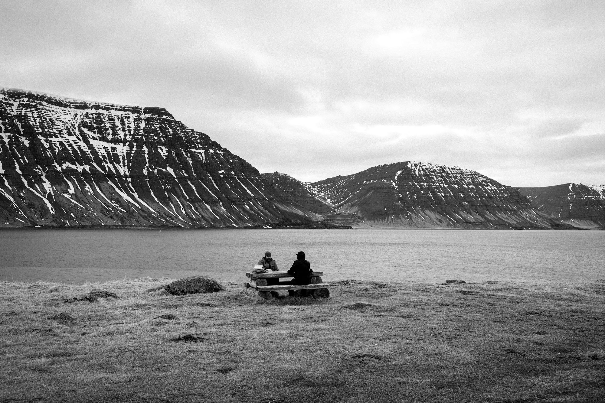 People sitting on bench eating black and white