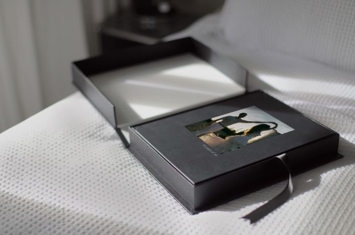 Photo of custom photo album in presentation box on a bed