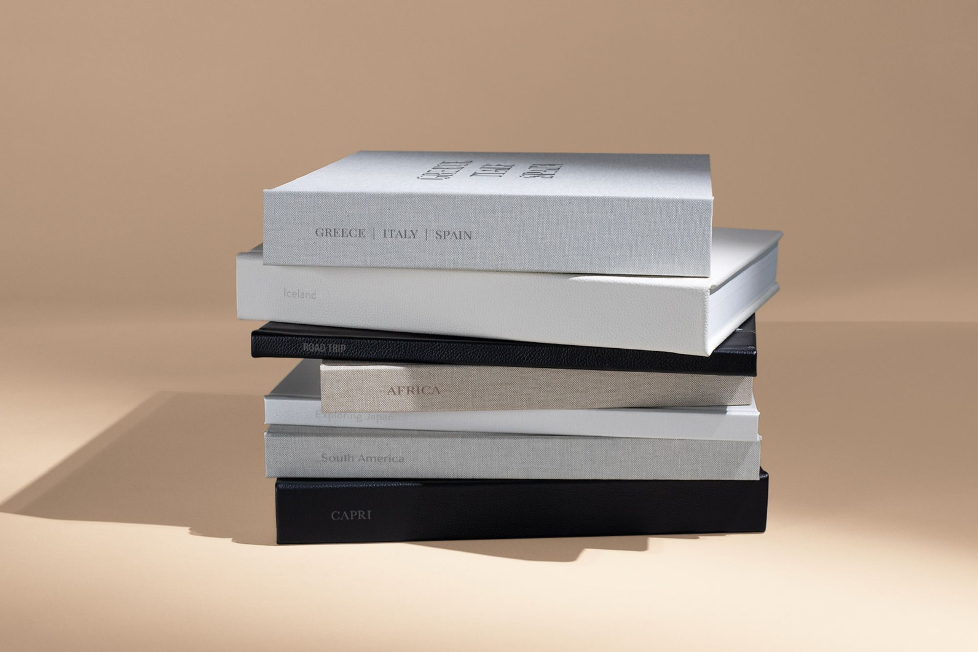 a stack of custom photo albums with spine text on an orange background