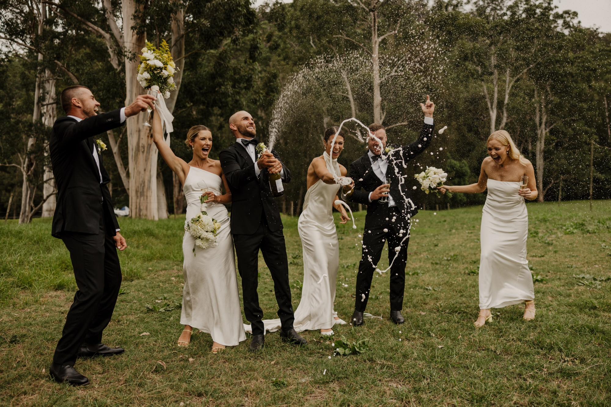 Wedding party celebrating and throwing champaign