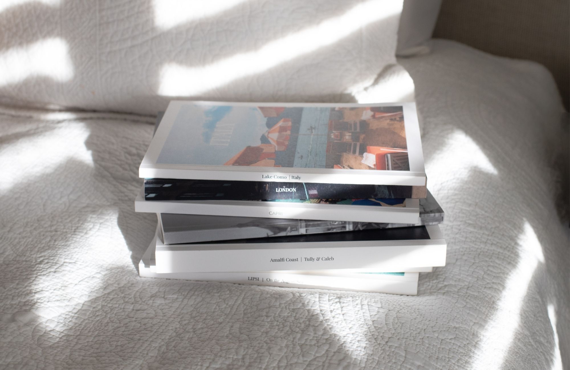 image of a stack of custom magazines on a white bed spread