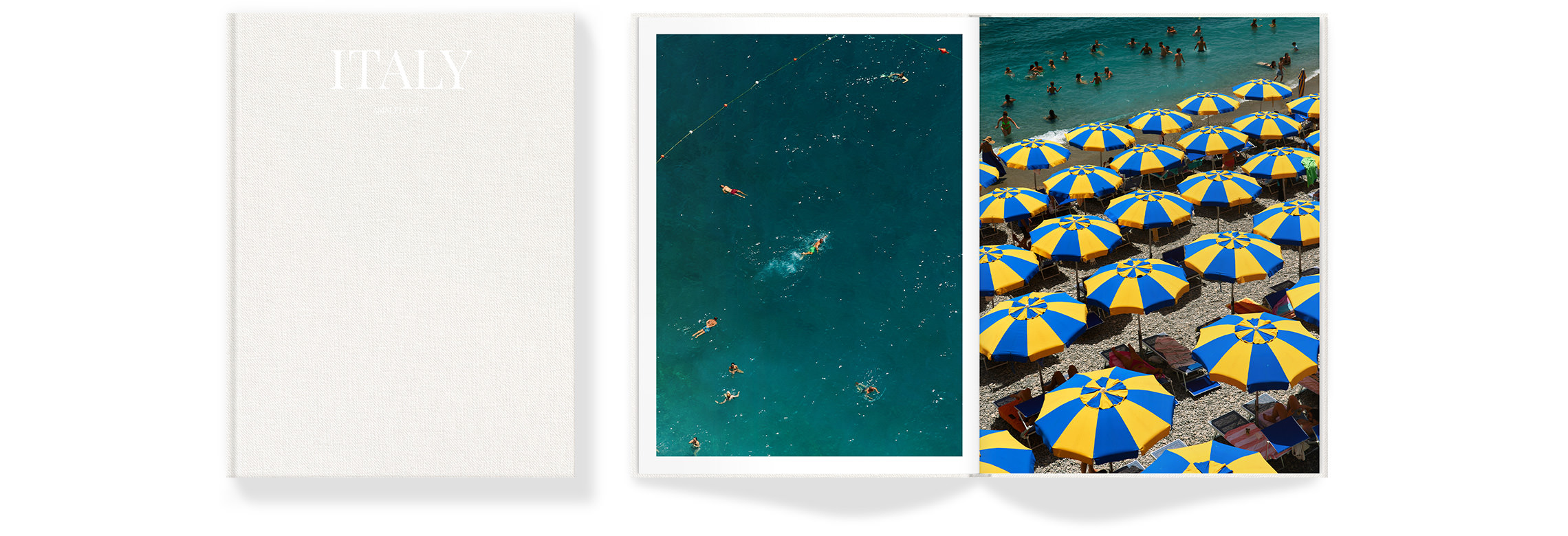 Bright blue and yellow sun umbrellas cover stony beach with many swimmers in shore water.