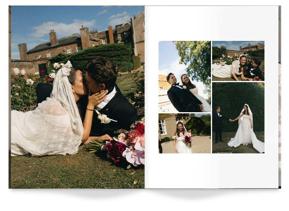 Newlywed couple kiss amongst flowers from bouquet while lying on grass.