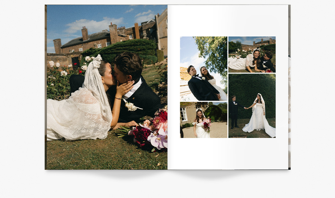 Newlywed couple kiss amongst flowers from bouquet while lying on grass.
