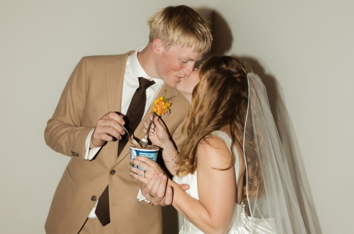 Couple kissing at wedding eating gelato