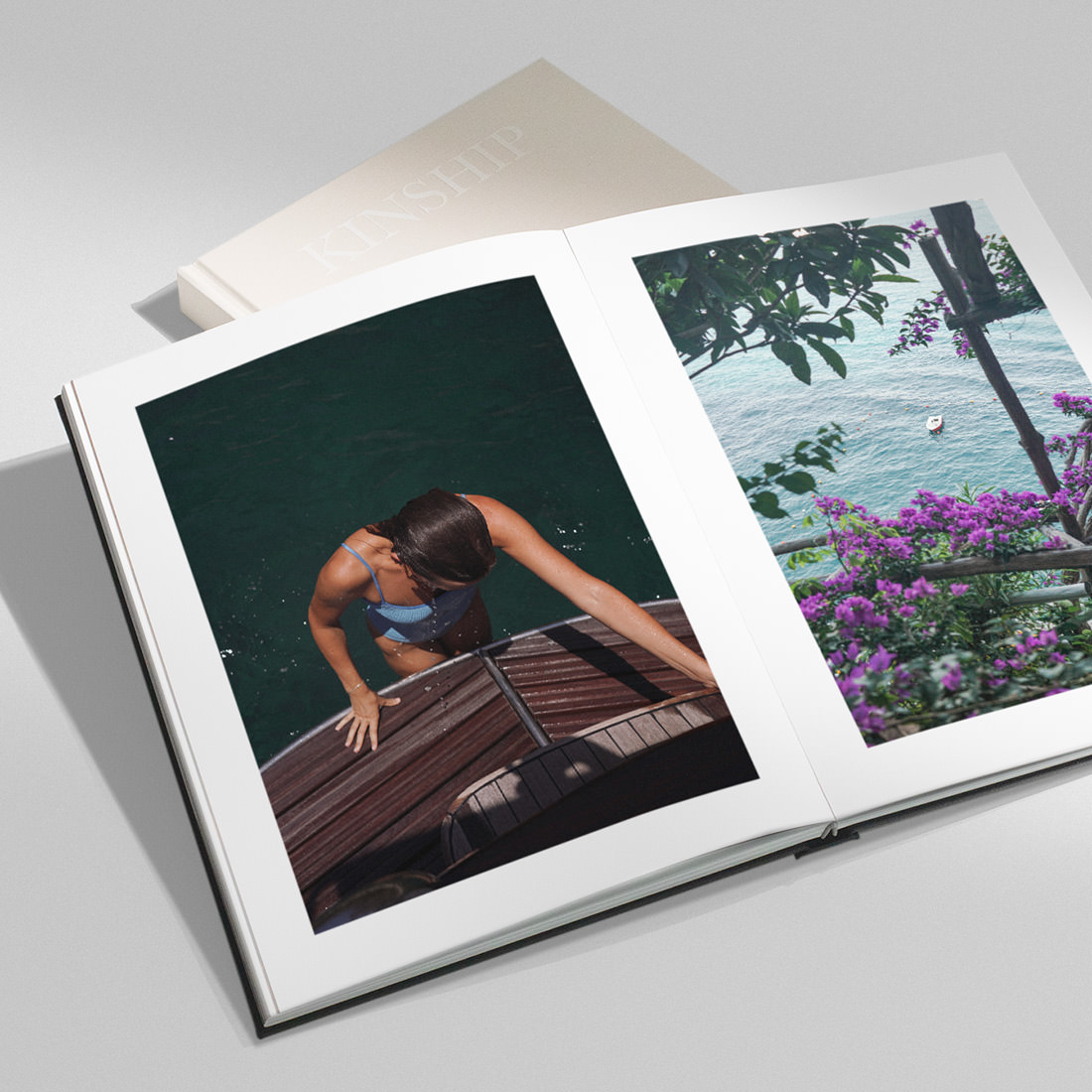 Black Portrait Premium Photo Book open revealing travel photos on double-page spread with 6 color printing.