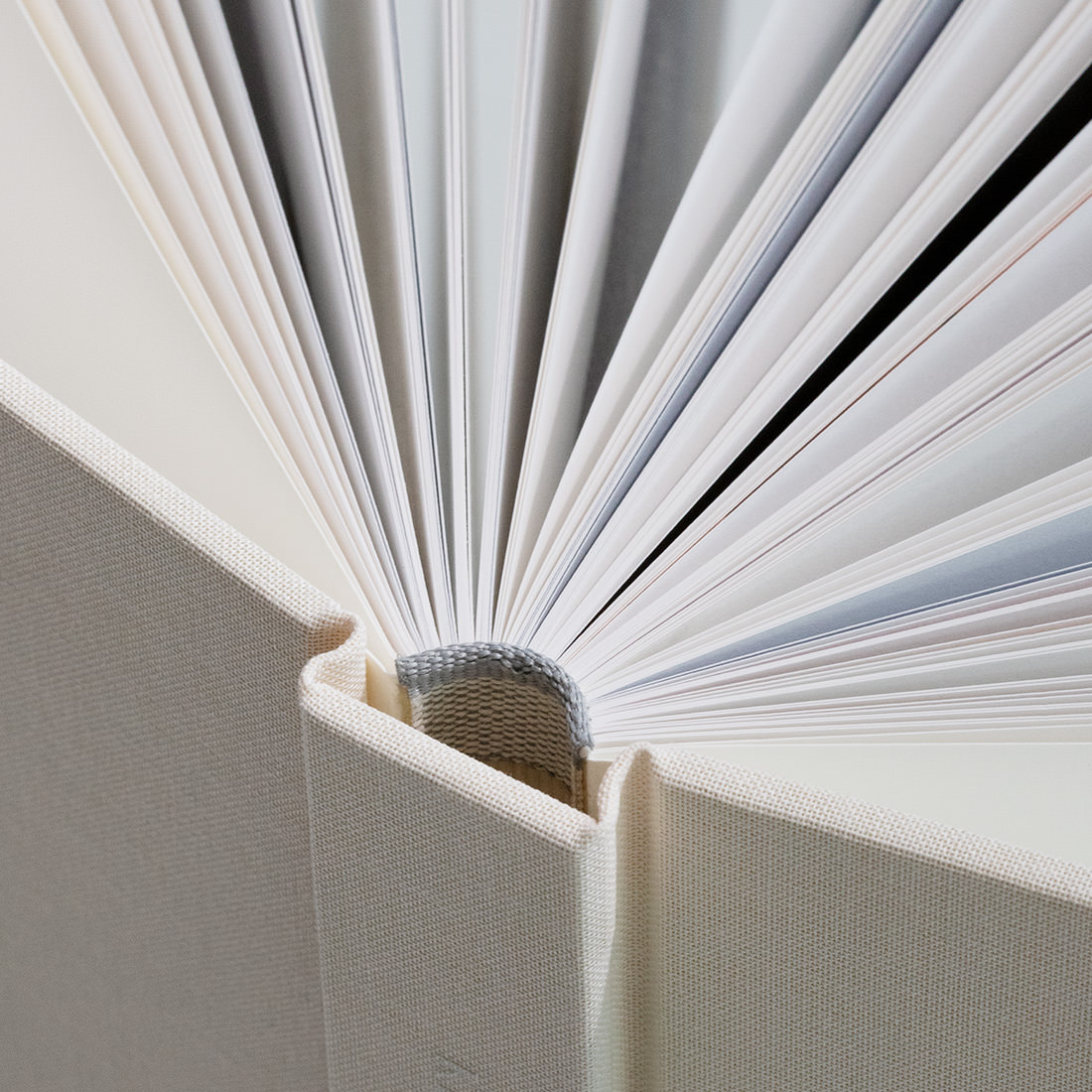 Close up of paper pages open and section-sewn binding of Premium Photo Books.