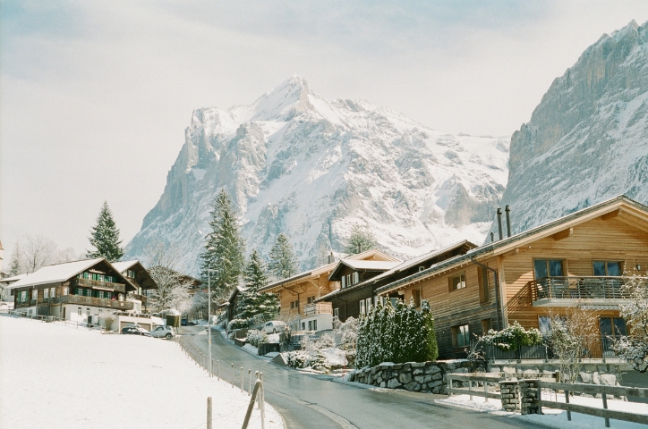 Photo of snowy town in Switzerland with mountains lining the background.
