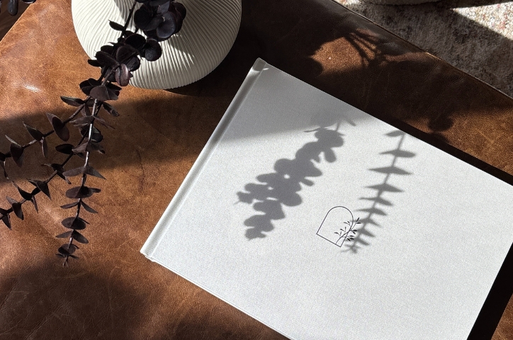 Photo of a photo book on table with shadows of foliage