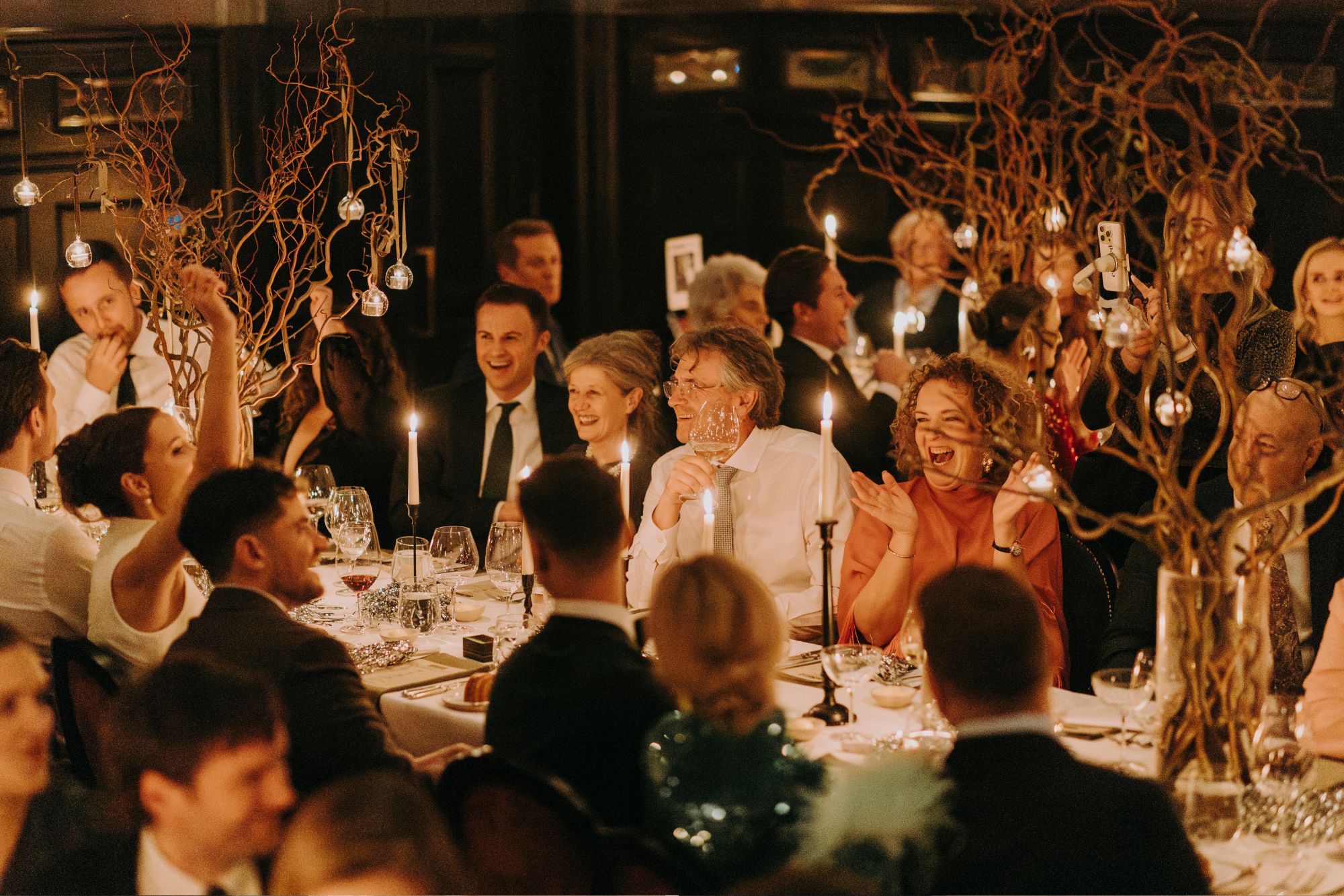 Reception party sitting at dinner table smiling