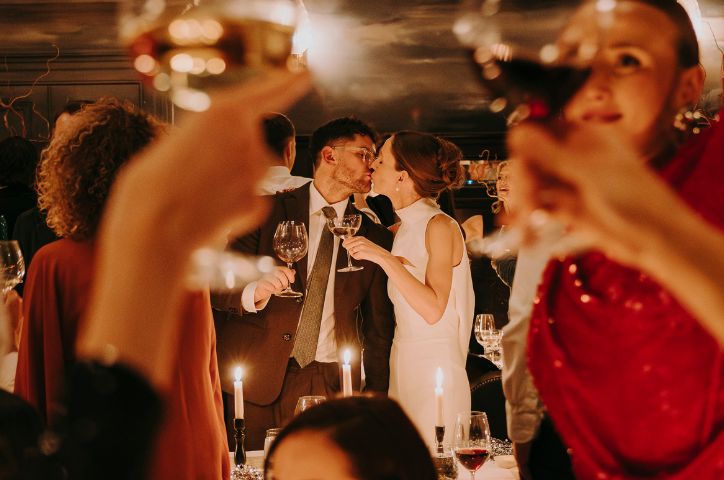 Bride and groom kissing inbetween their guests