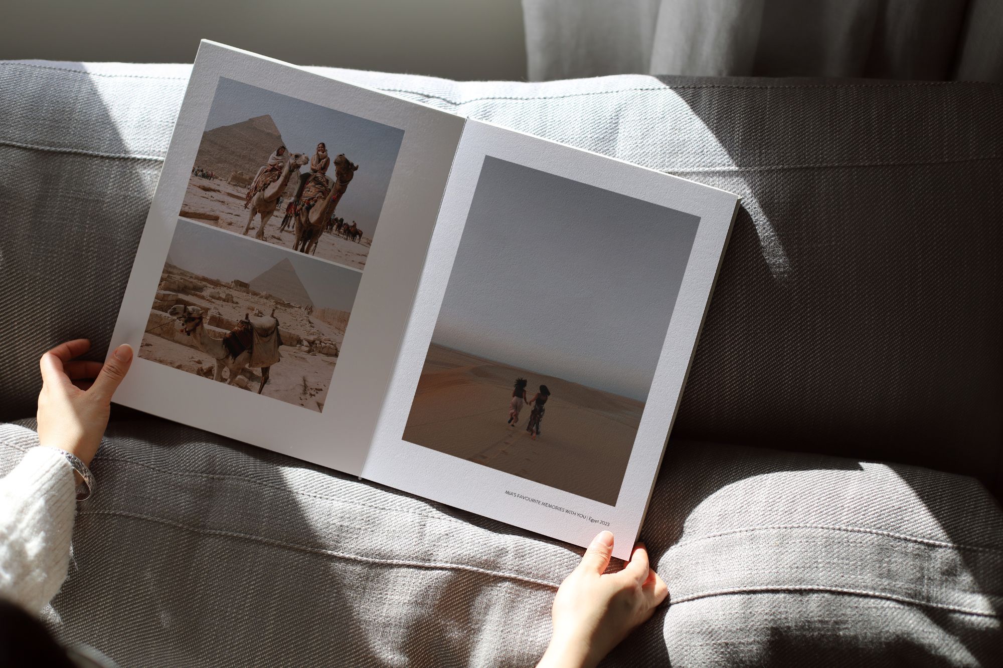 Person browsing open photo book with photos from Egypt