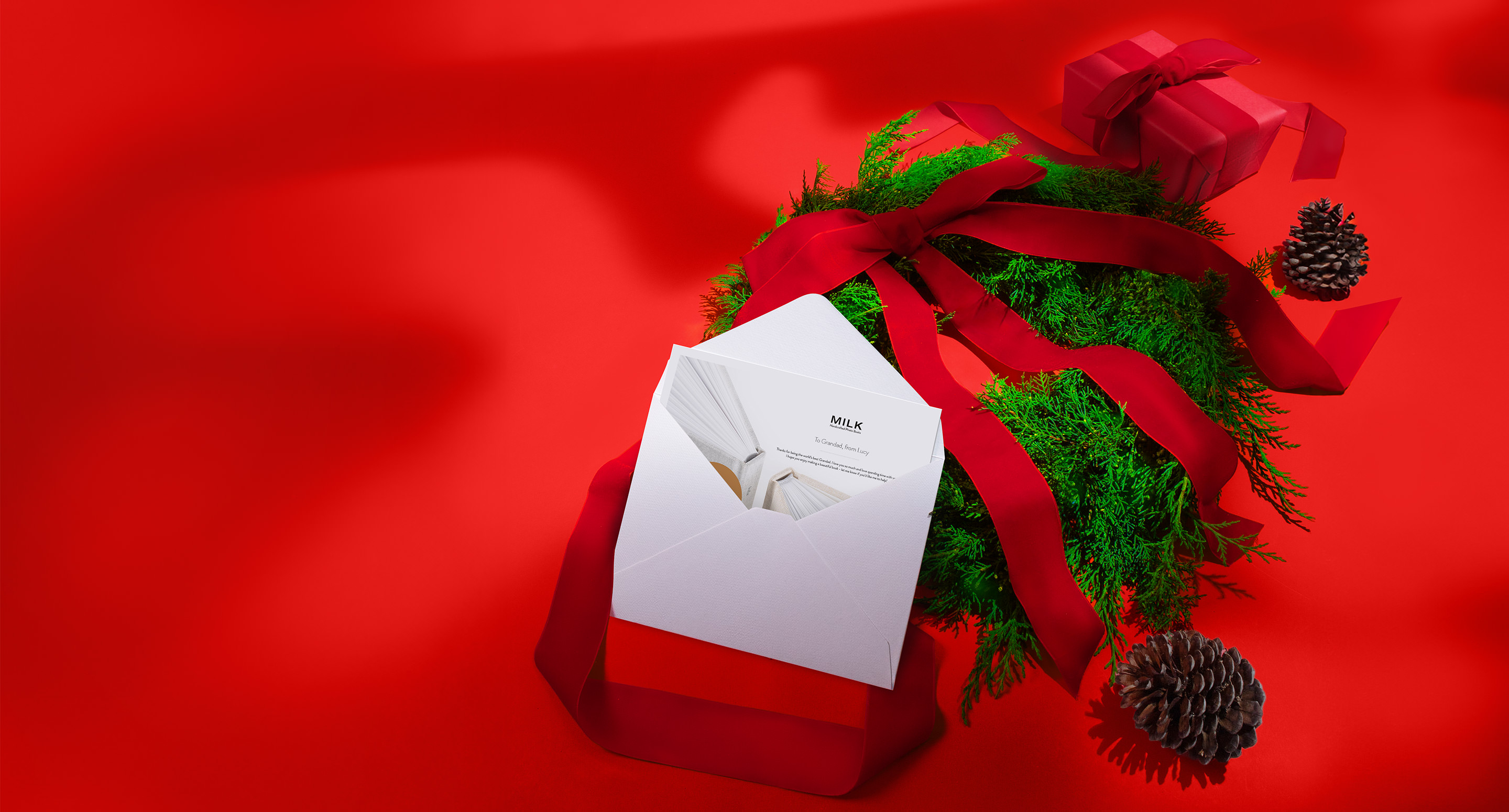 Open envelope with MILK Gift Voucher inside, on a Christmas themed red background.