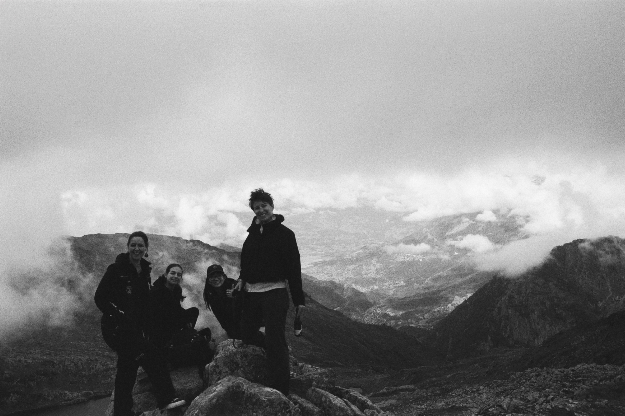 Group of four women smiling for photo in front of mountains in France.
