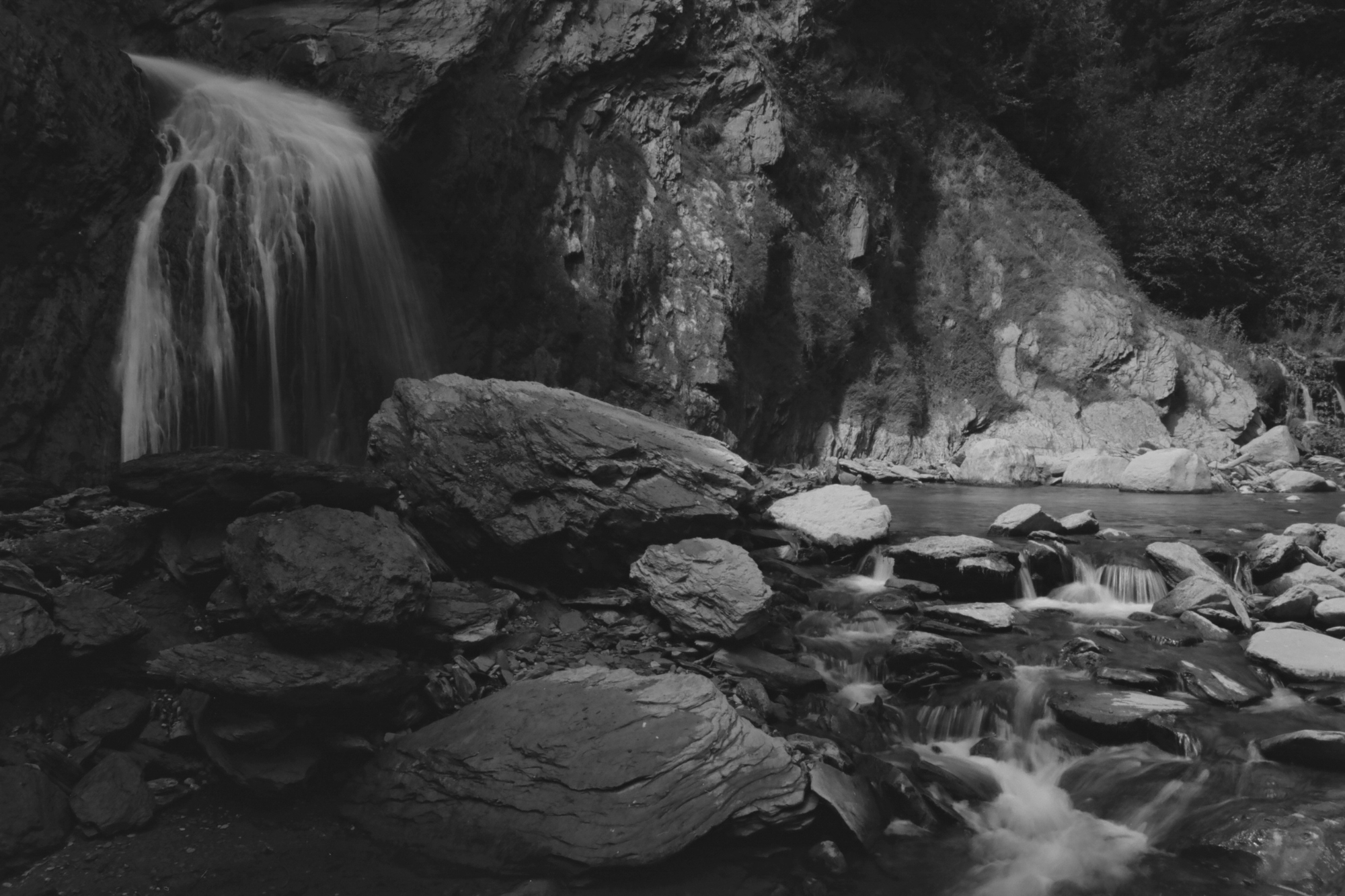 Small running waterfall with a flowing rocky creek.