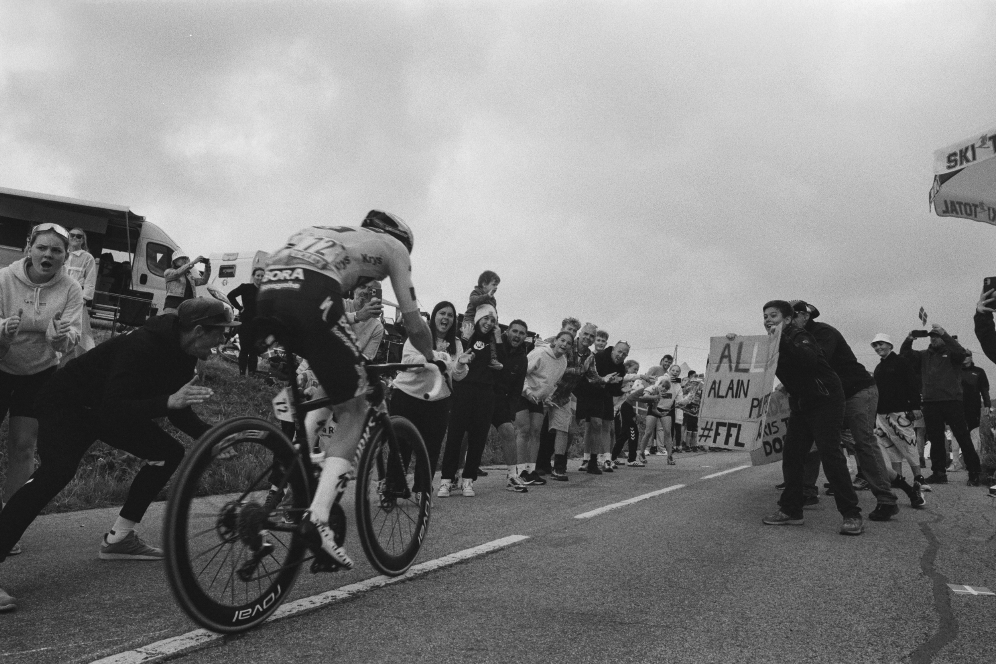 Biker in Tour de France being cheered on as he reaches finish line.