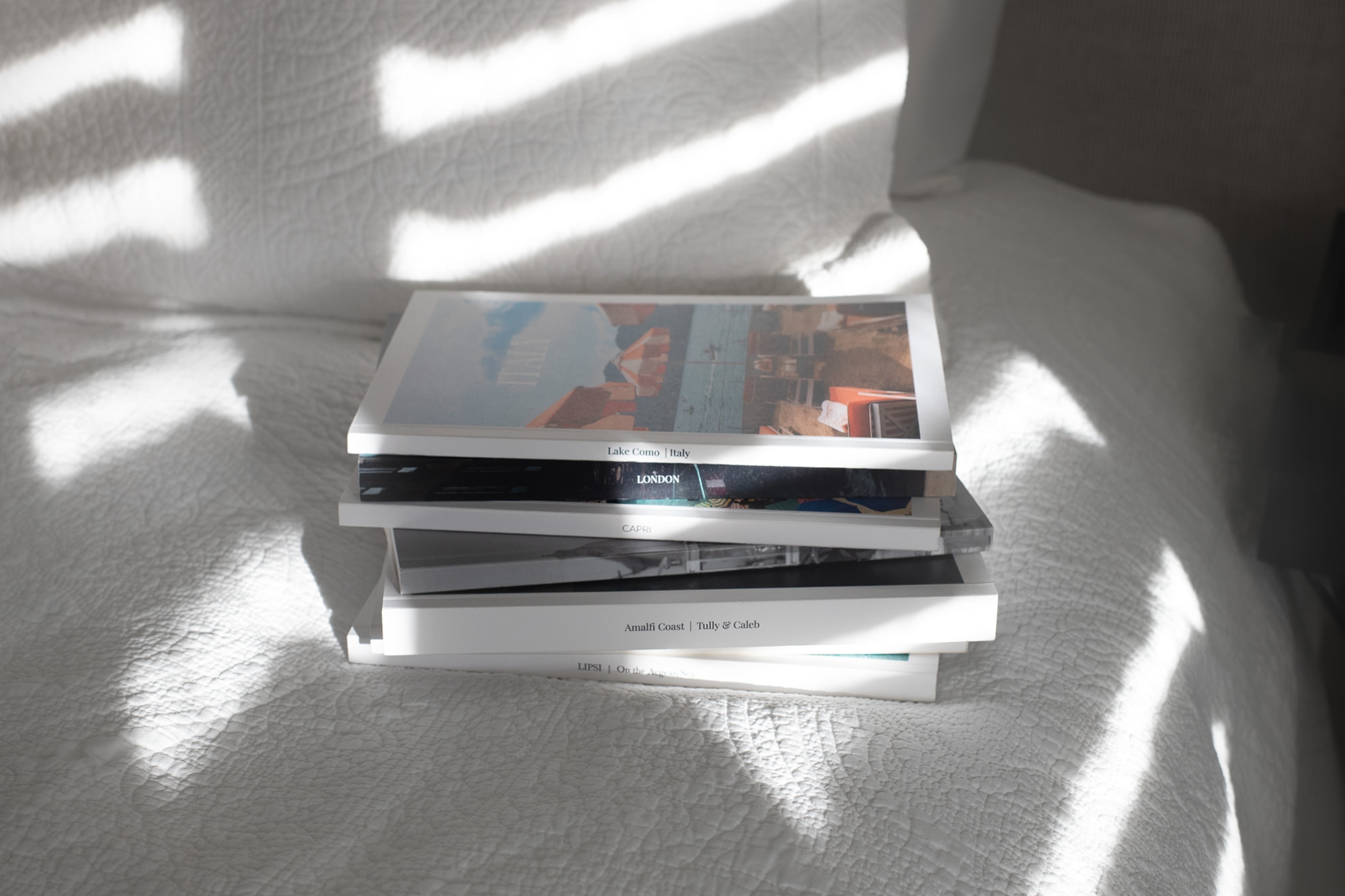 Stack of Mini Magazines on a bed spread.