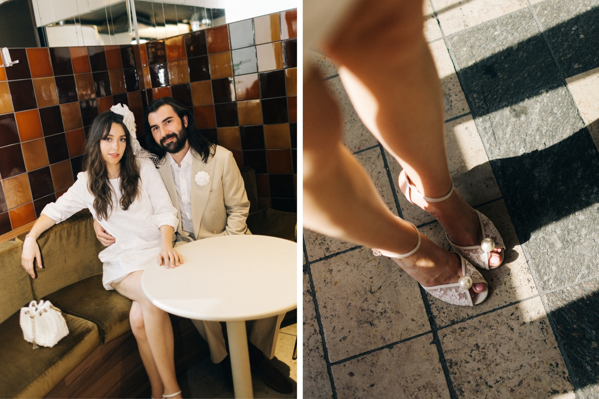Newlywed couple sit together in matching white attire on retro corner couch with table.