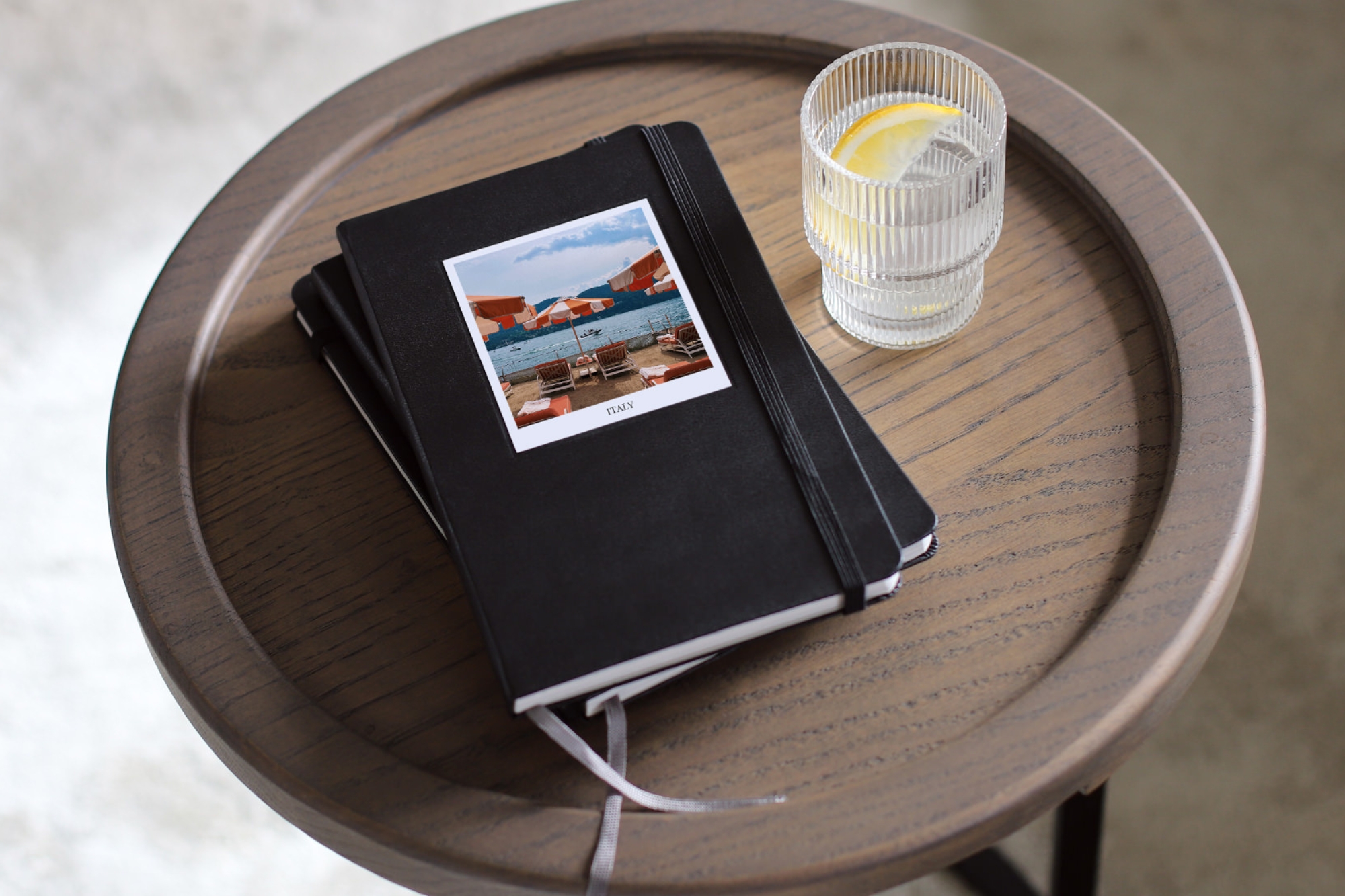 Stack of Moleskine Photo Books on wooden end table.
