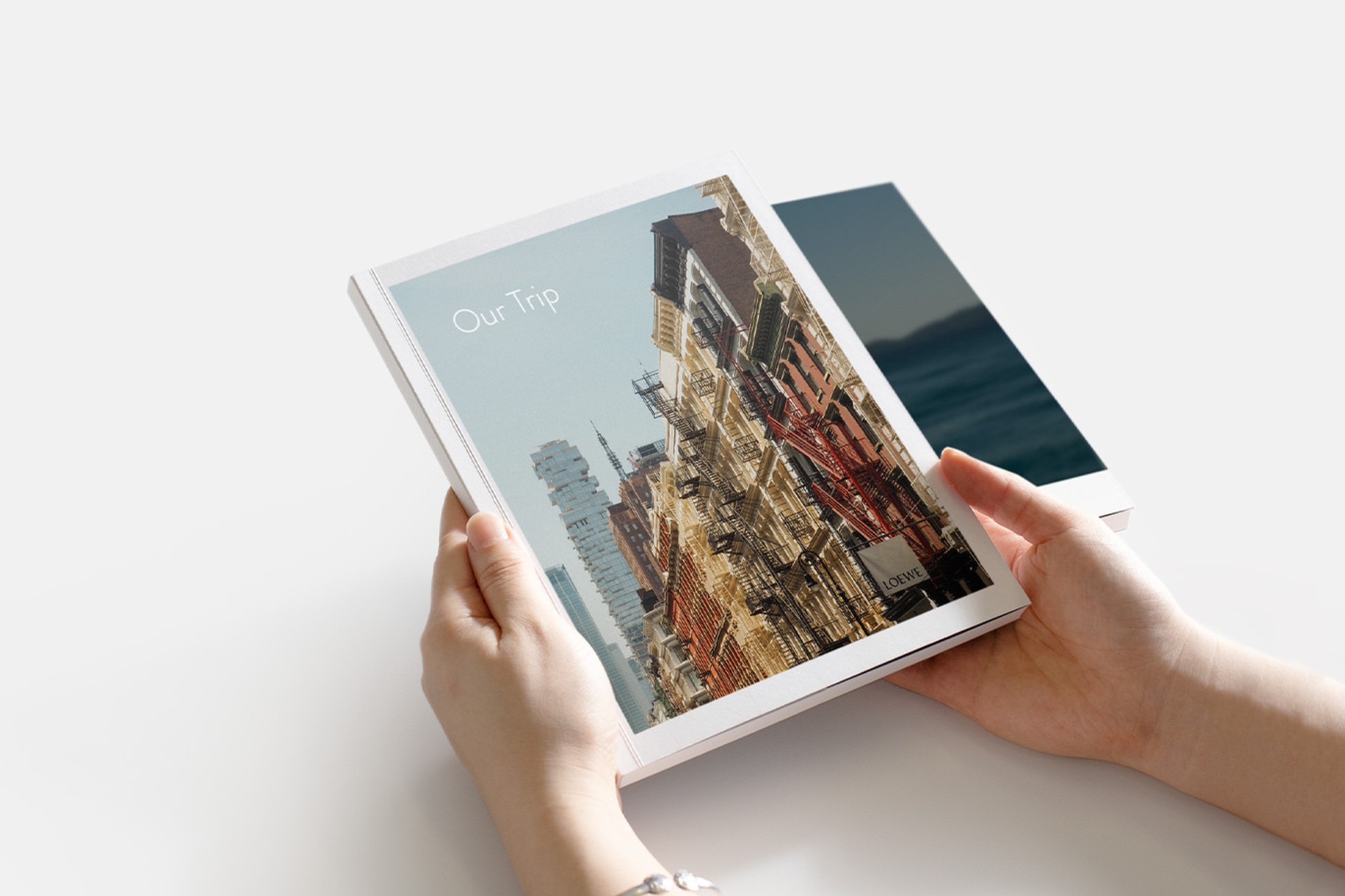 Holding a Portrait Softcover Travel Photo Book in hands.