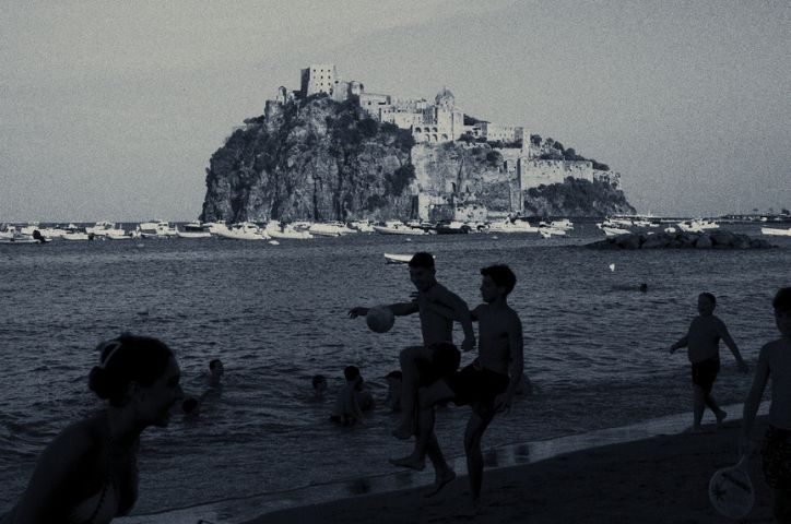 film photo of people playing football on a beach in black and white