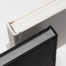 Disponível em branco (padrão) e preto, o cartão rígido forma a estrutura de cada página.