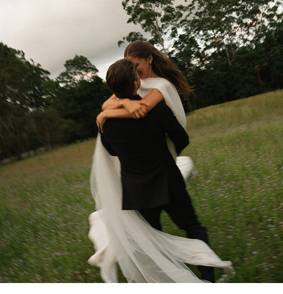 Newlywed photo portrait, couple embracing in field